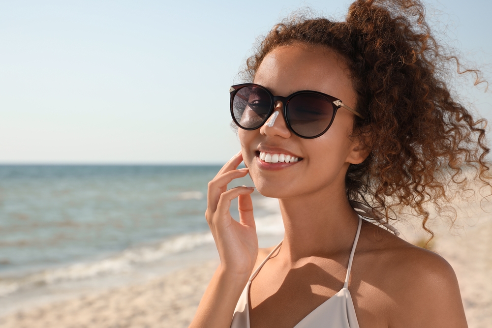 Four adults, two men and two ladies running towards the beach wearing bikinis and sunglasses - See Breeze Optometry