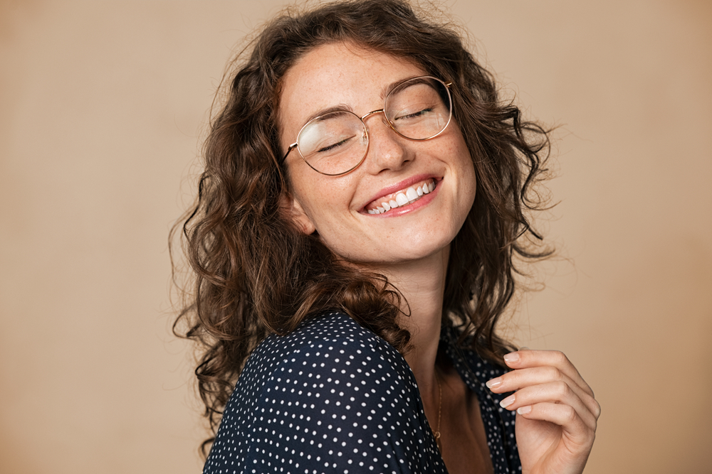 Woman wearing sunglasses doing stop sign - See Breeze Optometry