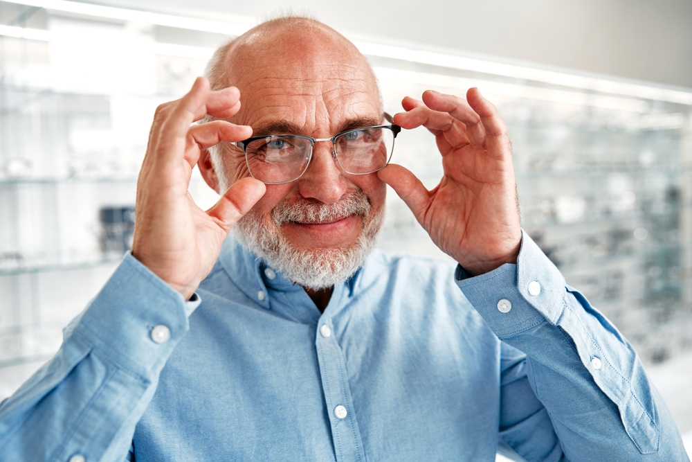 Middle-aged man holding glasses - Emergency Eye Care Huntington Beach