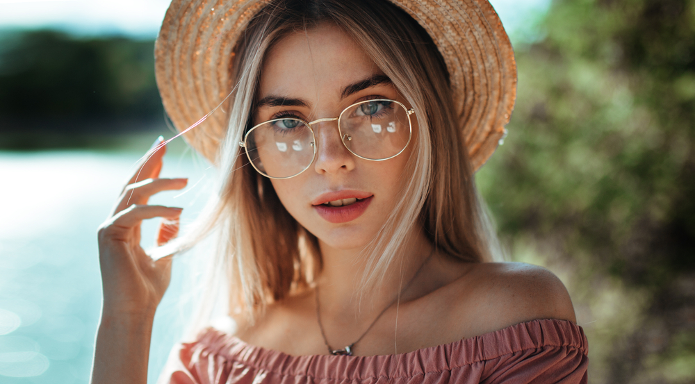 Woman with short hair wearing eye glasses and black blazer looking at the side - See Breeze Optometry