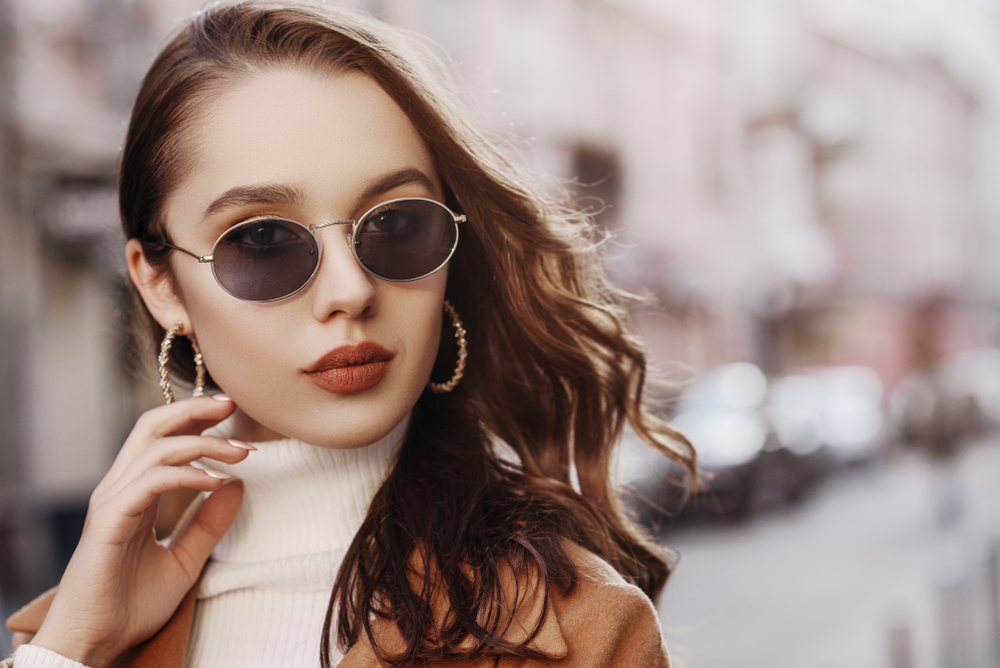 Woman wearing sunglasses doing stop sign - See Breeze Optometry